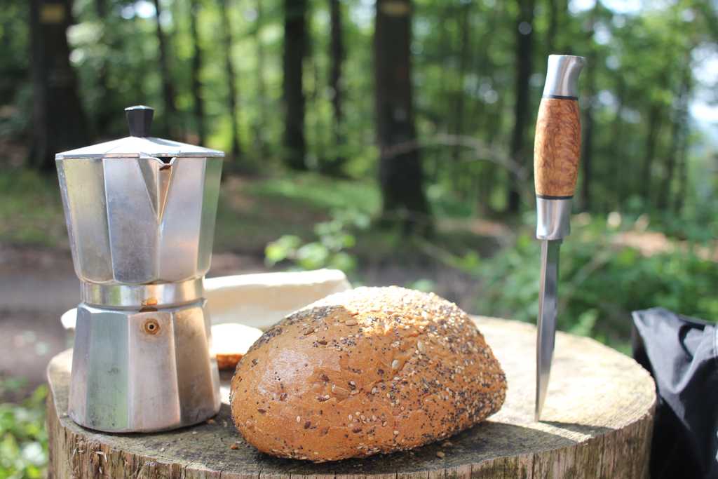 Ein Holzblock mit Brot, Messer und Kaffee